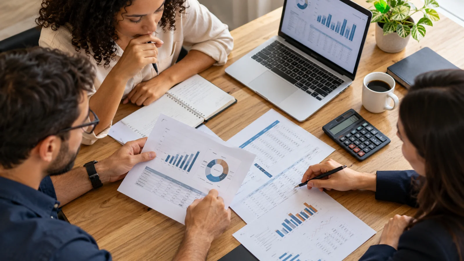 Equipe planejando investimentos de marketing com relatórios e calculadora.